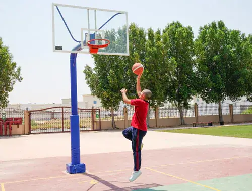 student playing basketball in school